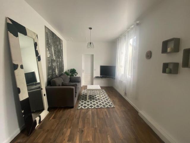 un salon avec un canapé et une table dans l'établissement La maison deThéo, à Les Pavillons-sous-Bois