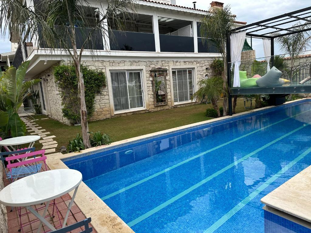a house with a swimming pool in front of a house at Grand Alaçatı Butik Hotel in Alaçatı