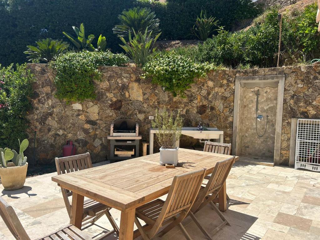 a wooden table with chairs and a laptop on it at Sale Marino - Goelba in Capoliveri