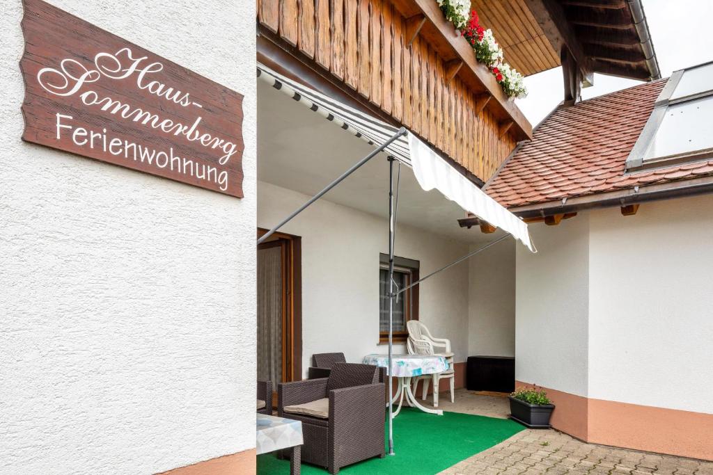 een bord aan de zijkant van een gebouw met een patio bij Haus Sommerberg in Titisee-Neustadt
