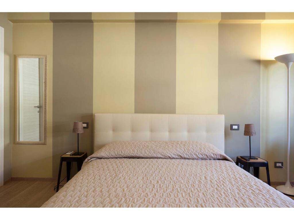 una camera da letto con un grande letto bianco con due comodini di Alex's Guest House a Roma