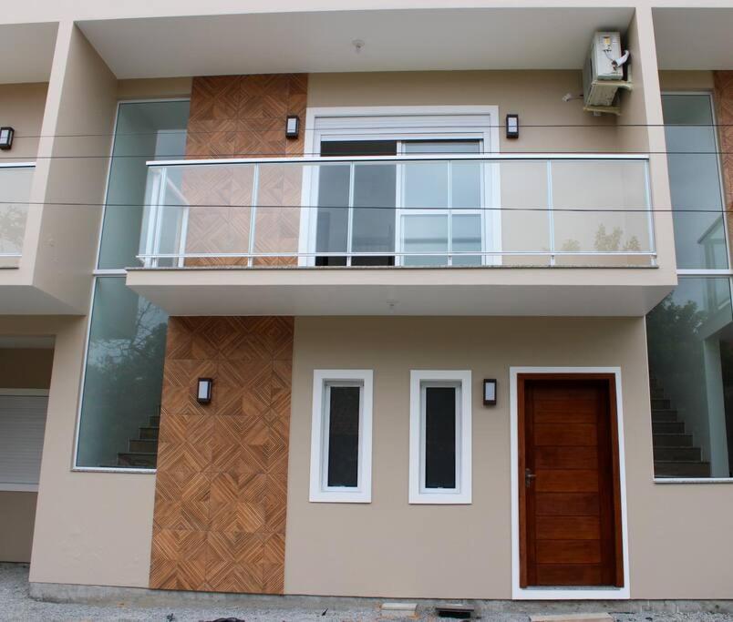 a building with a balcony on the side of it at Riviera de Garopaba Unidade Lumina - A Beira Mar in Garopaba