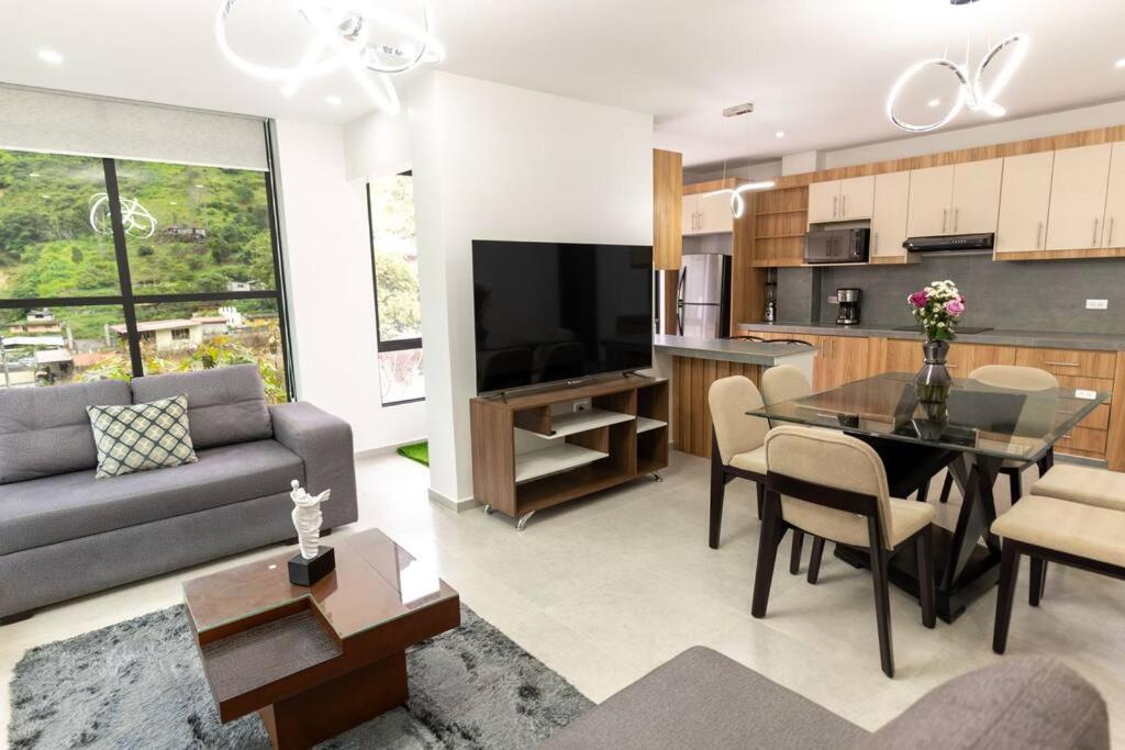 Una sala de estar con un sofá y un comedor. en MV Departamento 2, en Baños