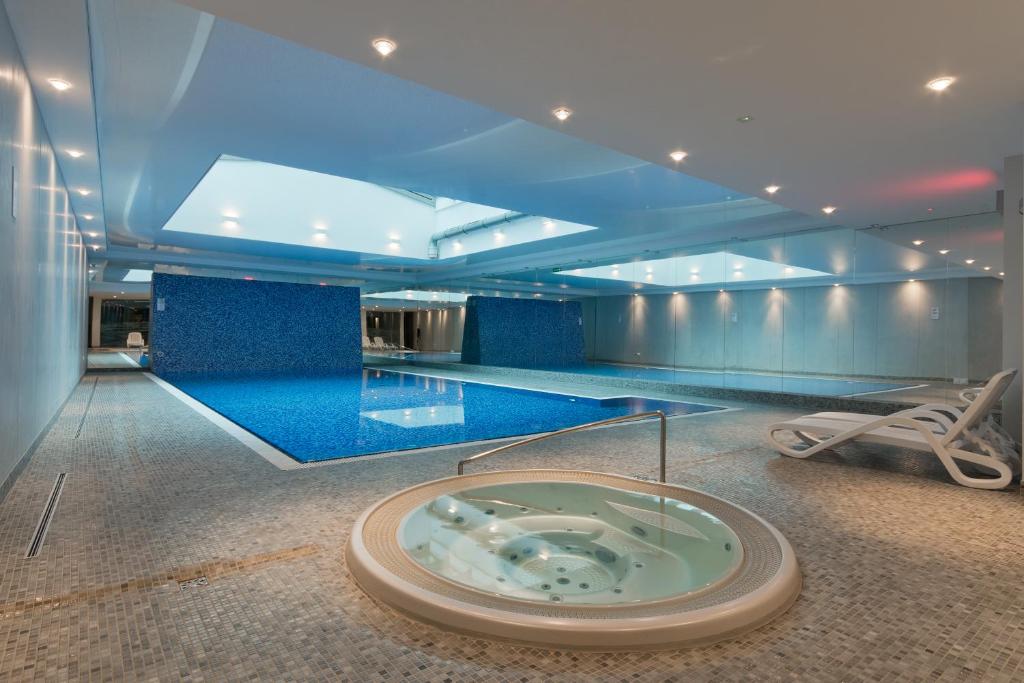 a swimming pool with a hot tub in the middle of a room at Apartamenty Gdańsk EU - Waterlane in Gdańsk