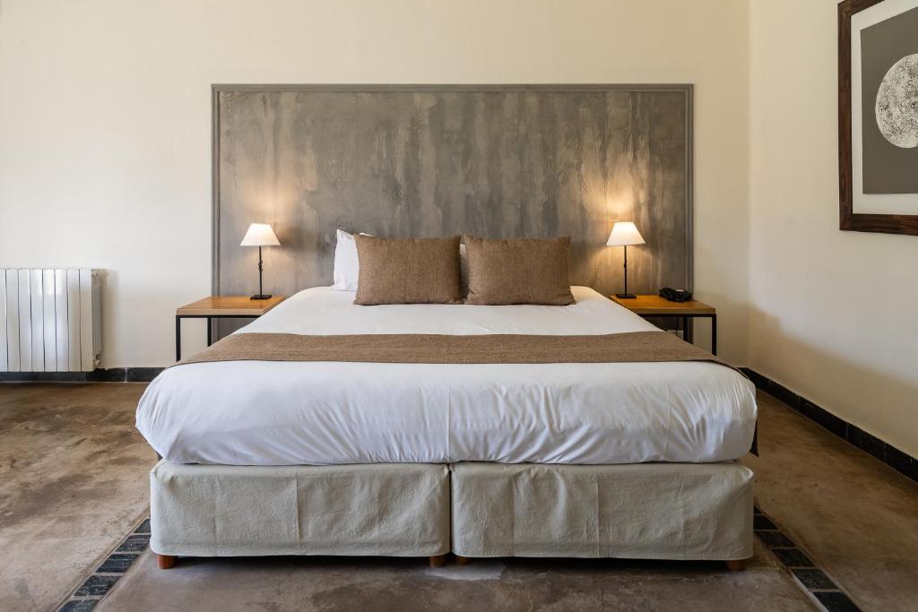 a bedroom with a large bed with two lamps at Villa Mansa in Vistalba