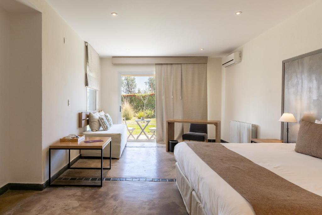 a hotel room with a bed and a couch at Villa Mansa in Vistalba