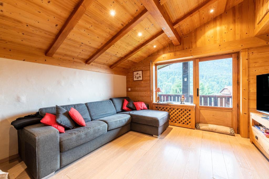 a living room with a couch and a large window at Appartement proche La Clusaz in Saint-Jean-de-Sixt