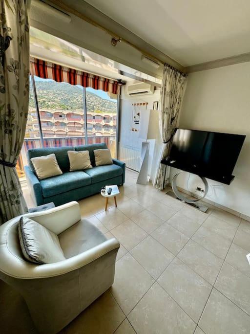 un salon avec un canapé et une télévision dans l'établissement 14468 deux pièces avec piscine, à Mandelieu-la-Napoule