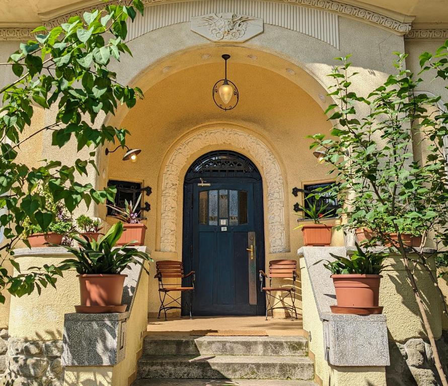 una puerta delantera de una casa con macetas en Magyaros-szecessziós Villa, en Budapest
