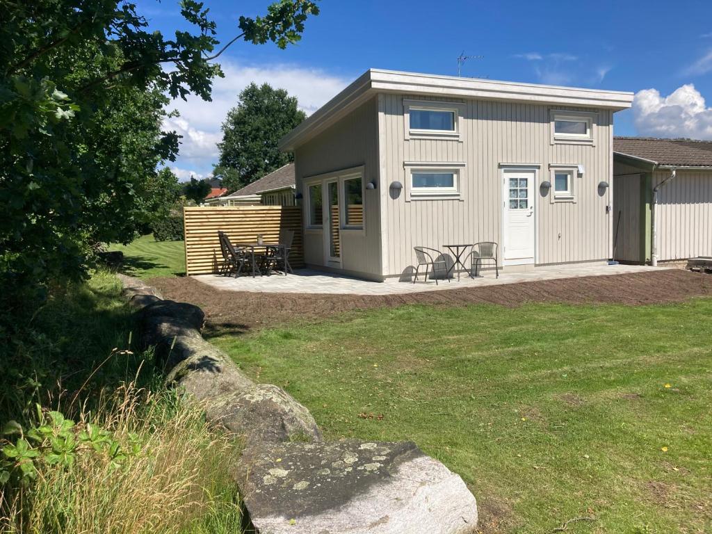 a shed with a table and chairs in a yard at Hultatorpet in Tvååker