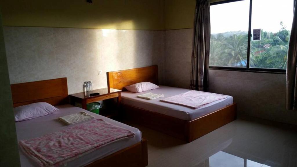 2 camas en una habitación pequeña con ventana en Sokcheav Guesthouse en Sen Monorom