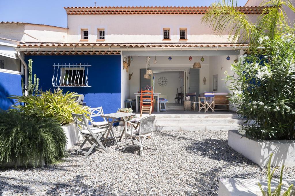 una casa con una pared azul, una mesa y sillas en Villa Baliba, en Hyères