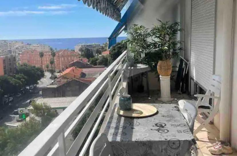 un balcon avec une table et une vue sur une ville dans l'établissement T2 Vue Mer, à Cannes