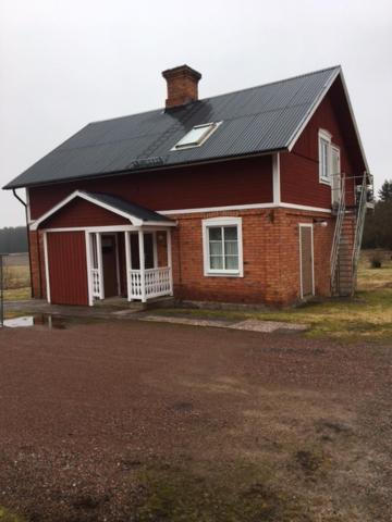 a small red house with a black roof at Stora Skedvi in Stora Skedvi