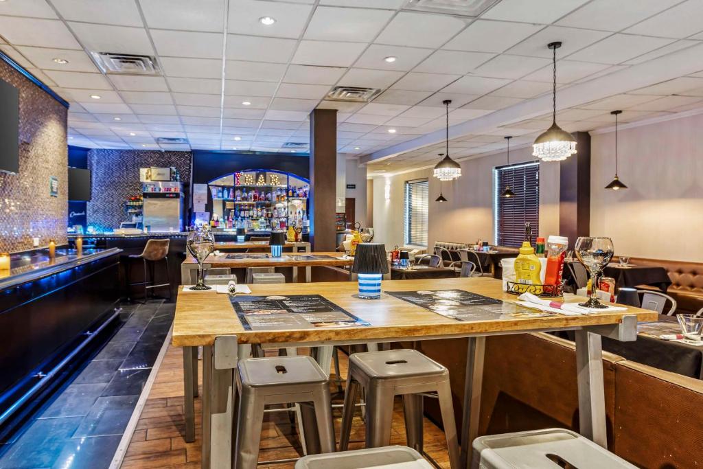 a bar with a table and stools in a restaurant at Best Western Plus Newark Airport West in Newark