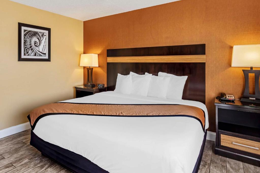 a large bed in a hotel room with two lamps at Best Western Plus Newark Airport West in Newark