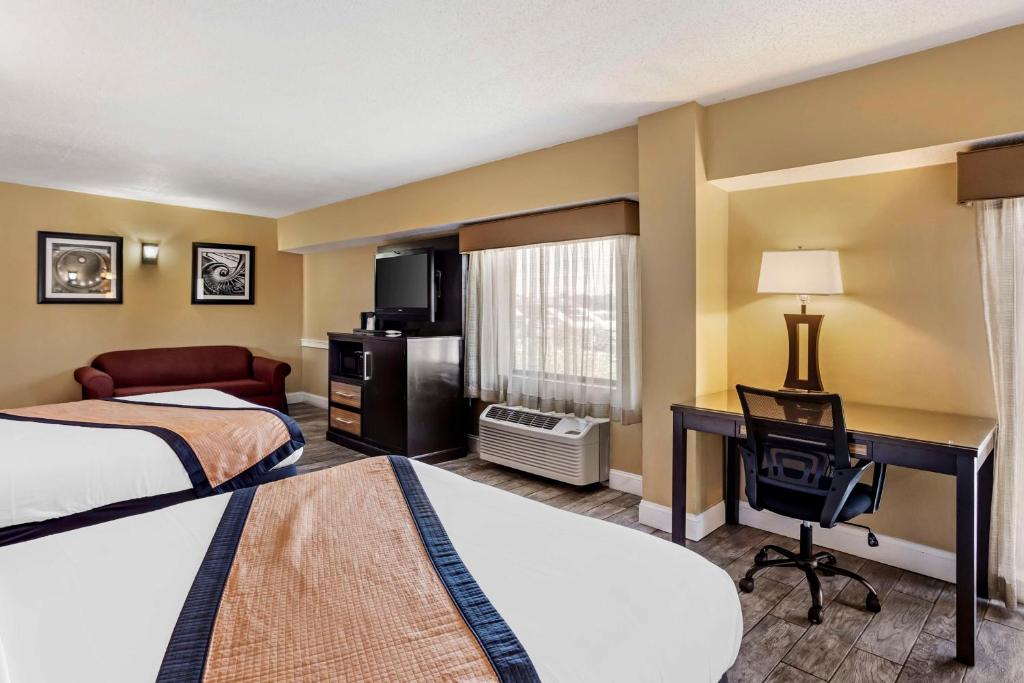 a hotel room with two beds and a desk at Best Western Plus Newark Airport West in Newark