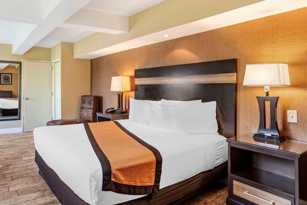 a hotel room with a large bed and a desk at Best Western Plus Newark Airport West in Newark