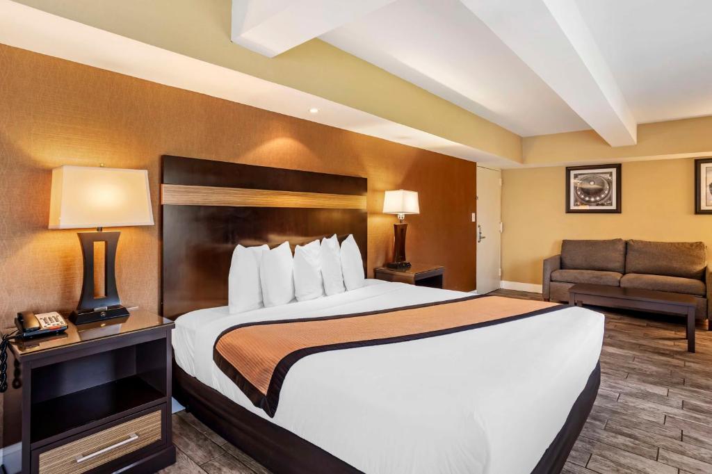 a hotel room with a large bed and a chair at Best Western Plus Newark Airport West in Newark