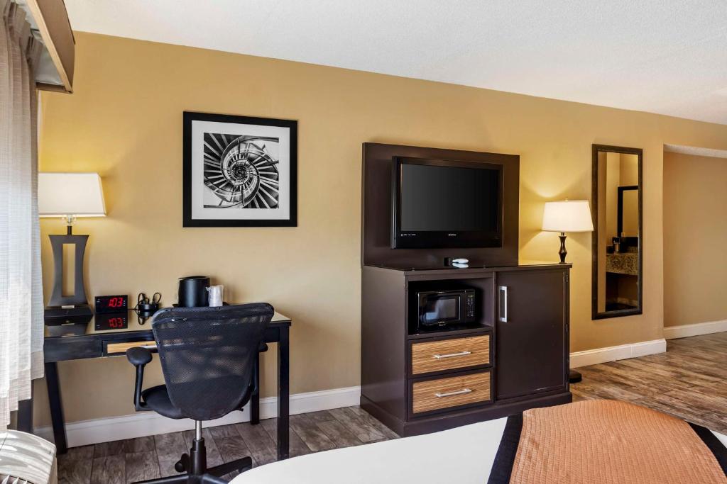 a hotel room with a tv and a desk with a chair at Best Western Plus Newark Airport West in Newark