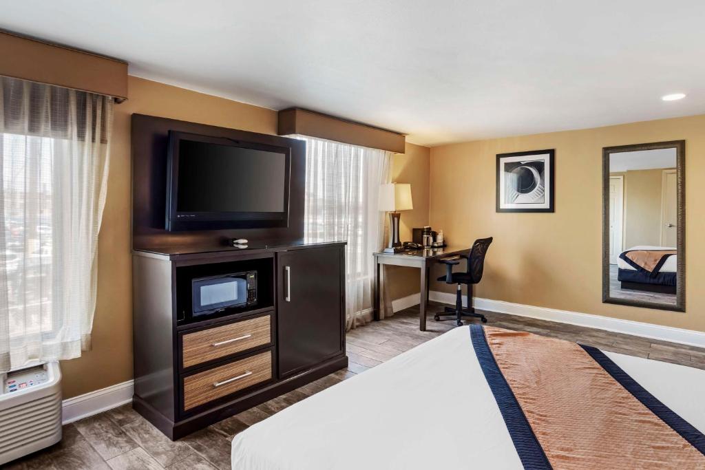 a hotel room with a bed and a flat screen tv at Best Western Plus Newark Airport West in Newark