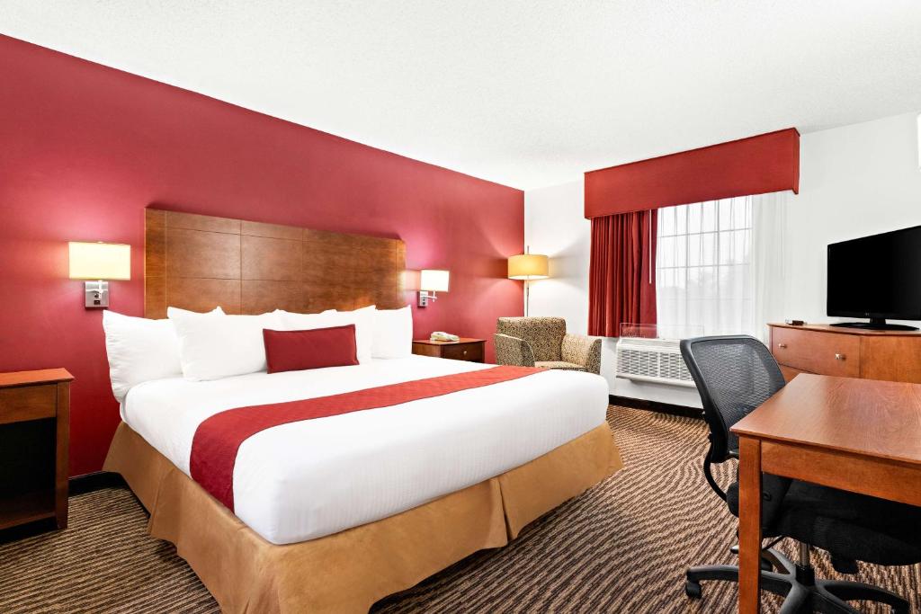 a hotel room with a large bed and a desk at Best Western Okmulgee in Okmulgee