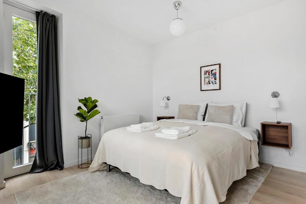 a white bedroom with a white bed and a window at Cosy 4-Person Apartment in The Heart of Aarhus in Aarhus