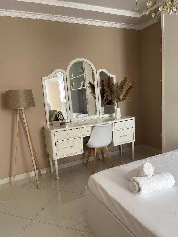a bedroom with a white dresser and a mirror at Edion Center Apartment in Shkodër