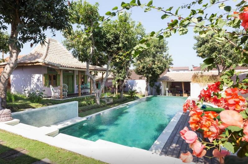 a swimming pool in the backyard of a house at Guesthouse Mooz in Canggu