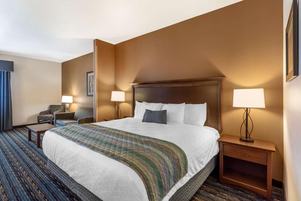 a hotel room with a large bed and a chair at Best Western PLUS Casper Inn & Suites in Casper