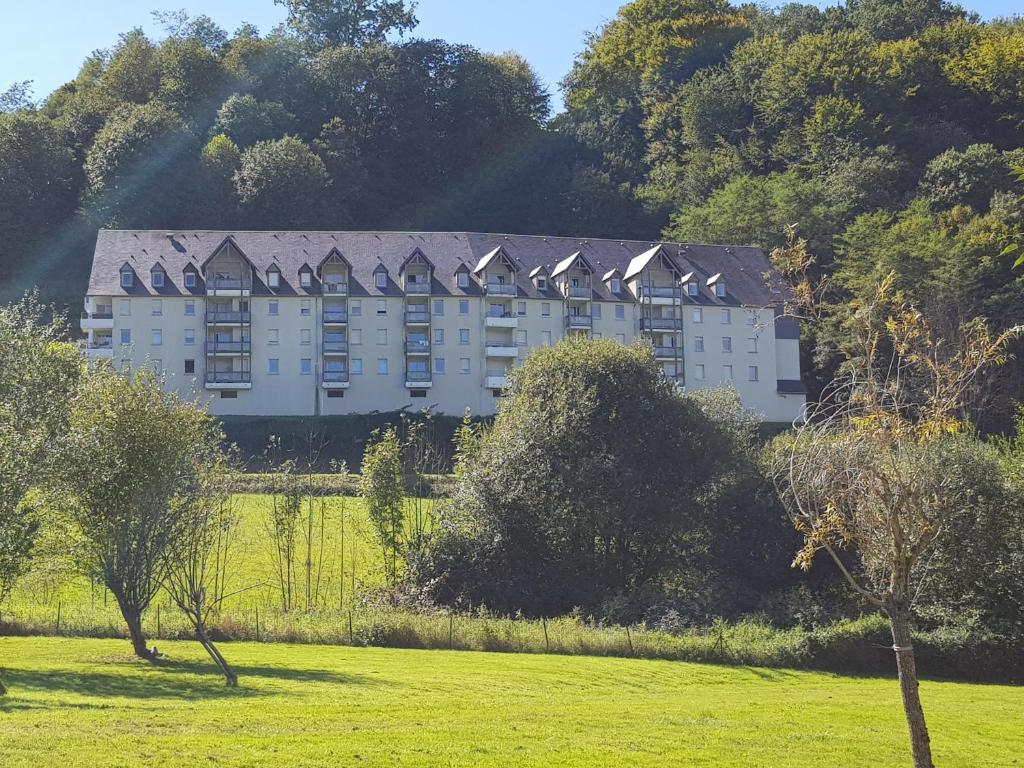 un grand bâtiment blanc au milieu d'un champ dans l'établissement Soleil 65, à Bagnères-de-Bigorre