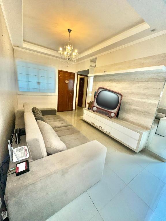 a living room with a couch and a tv at Casa Familiar Locação Semanal Maringa in Maringá