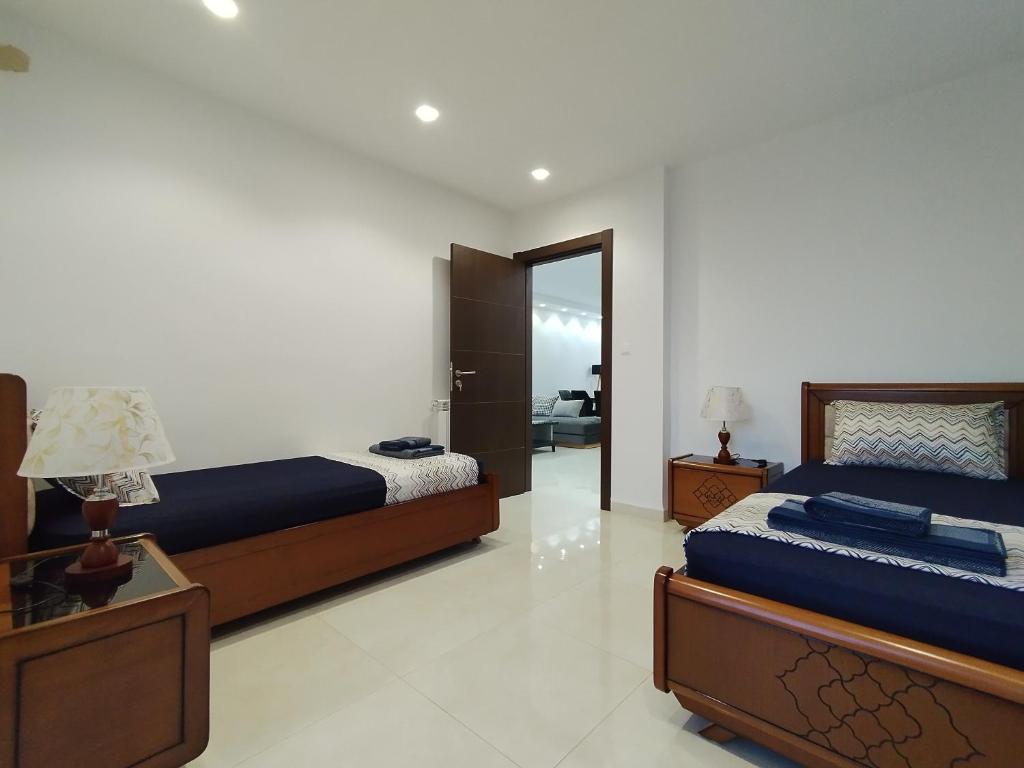 a bedroom with two beds and a mirror at Luxueux Appartement à Tlemcen in Tlemcen