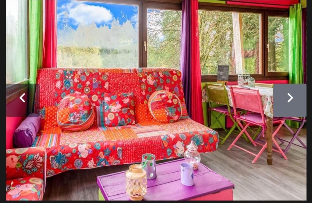 un soggiorno con un divano rosso e un tavolo di Yourte Mongole et cabane a Houffalize
