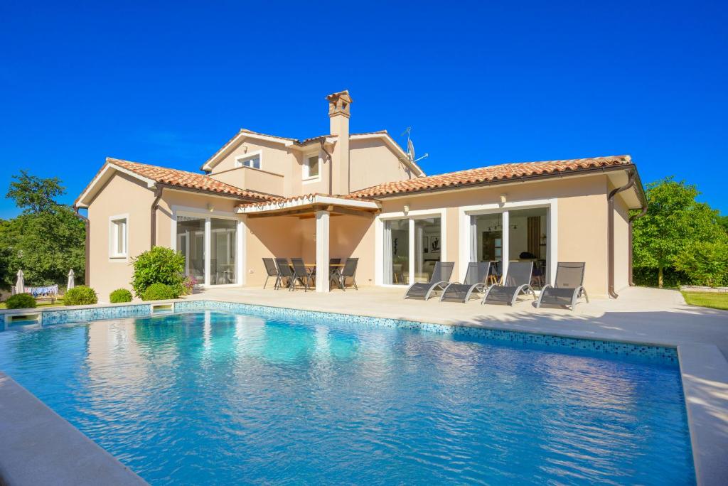a villa with a swimming pool in front of a house at Villa Emili by IstriaLux in Svetvinčenat