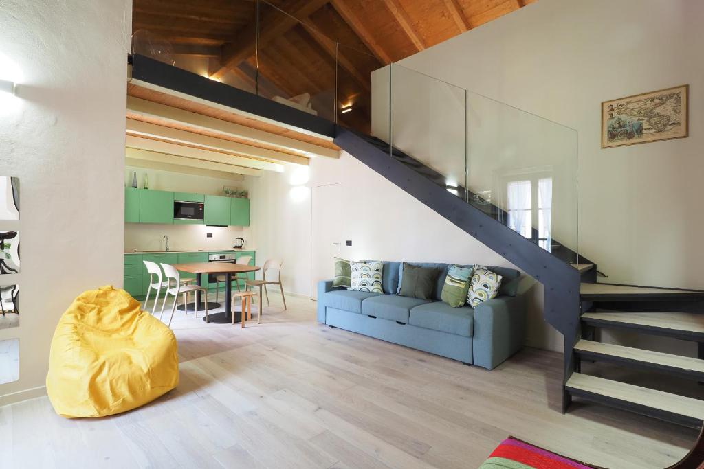 a living room with a blue couch and a staircase at PrimoPiano - Zumbini G in Milan