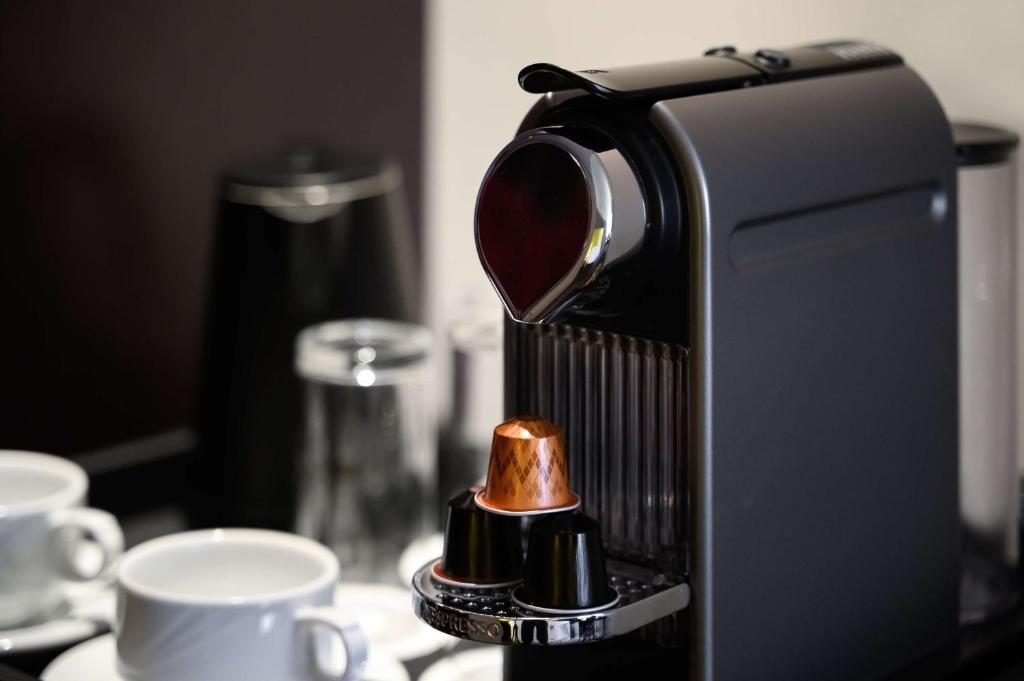a coffee machine sitting on top of a table with cups at Radisson Blu Hotel & Resort, Abu Dhabi Corniche in Abu Dhabi