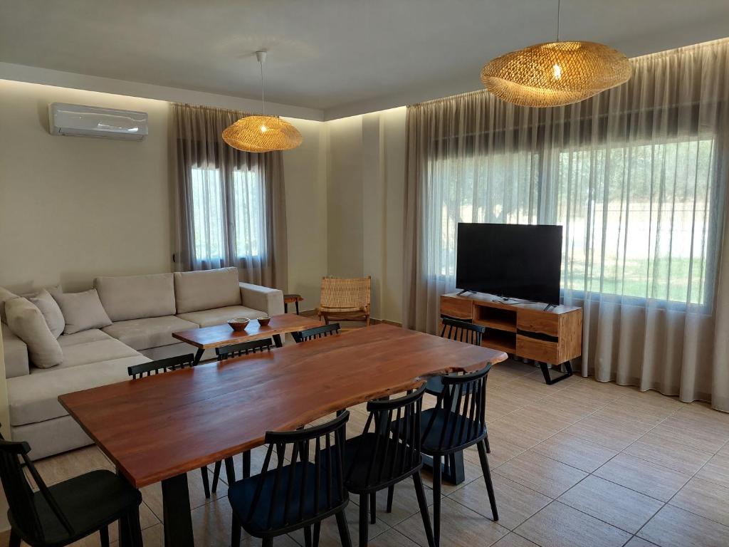 a living room with a couch and a table and chairs at VENTO villa neriana in Khainderianá