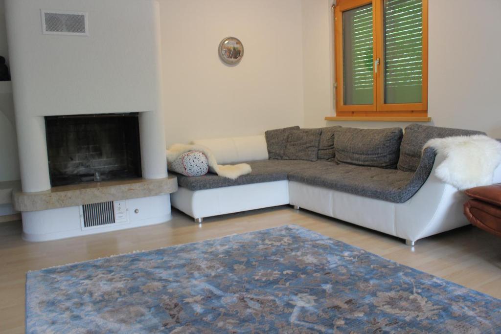 a living room with a couch and a fireplace at Rietidylle mit atemberaubendem Blick auf die Churfirsten in Wildhaus