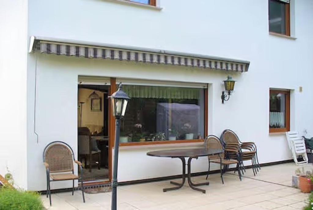a patio with a table and chairs and a window at Ferienwohnung Petryk in Weinheim