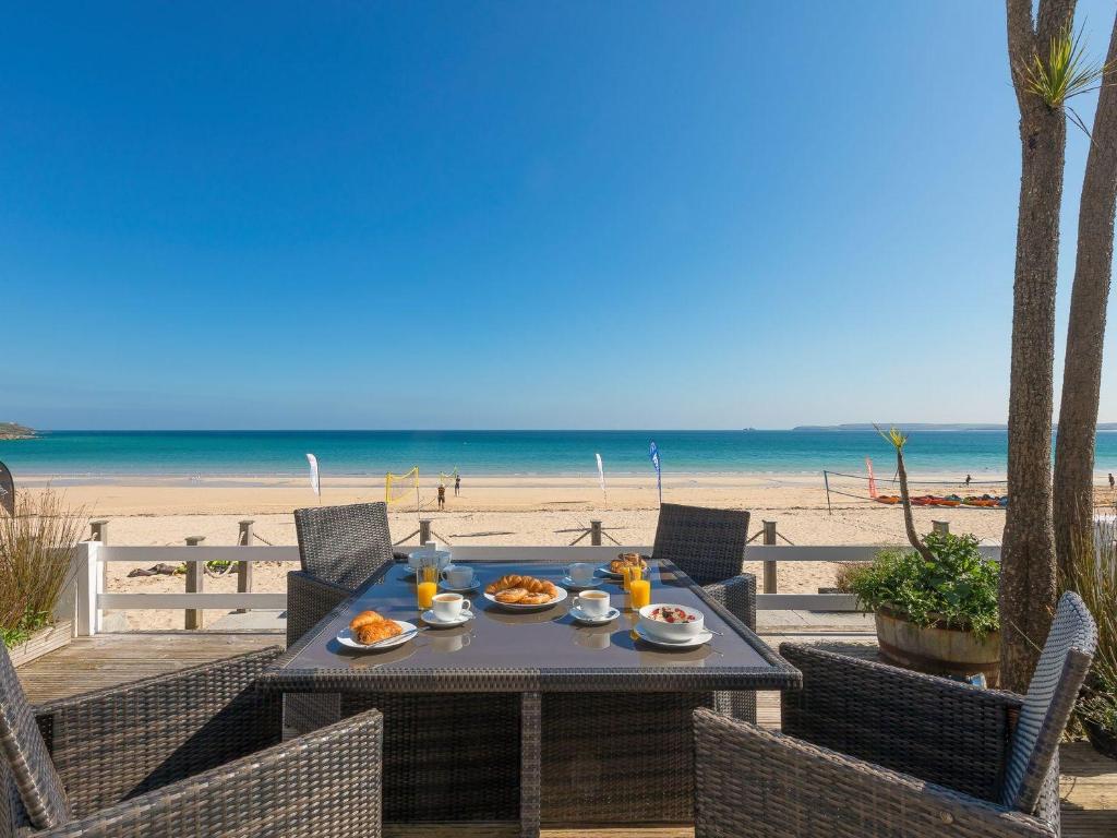 a table with plates of food on the beach at Seaspray in St Ives