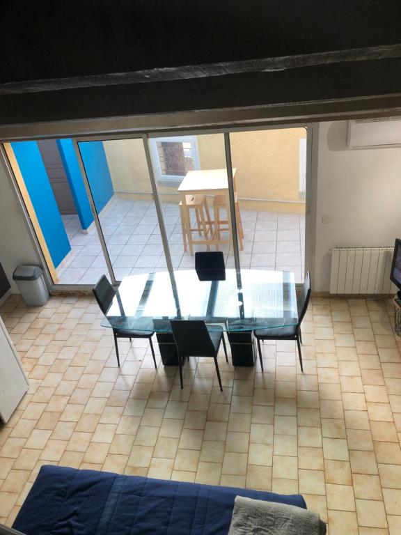 une table et des chaises en verre dans une chambre avec vue dans l'établissement Mistral 2 étage D avec clim, à Coursan