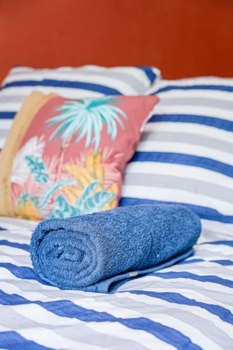 - une serviette bleue assise au-dessus d'un lit avec des oreillers dans l'établissement Montevrain disney 10mn Parking privé, à Montévrain