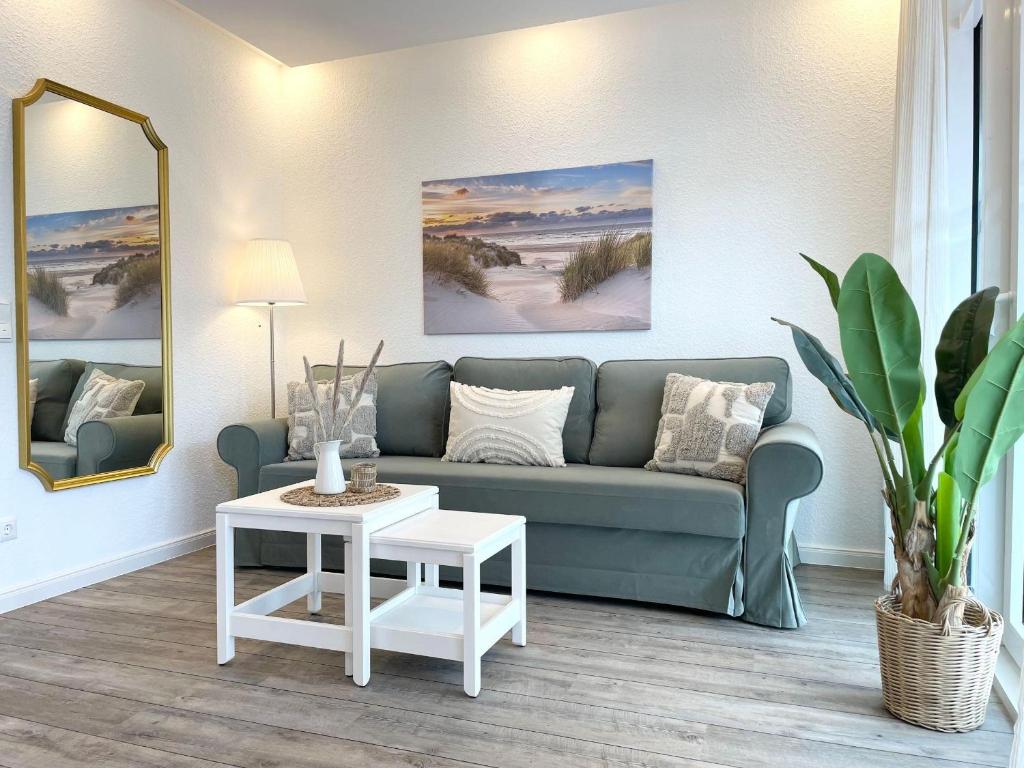ein Wohnzimmer mit Sofa und Tisch in der Unterkunft Haus Nordseebrandung FeWo 3 in Cuxhaven