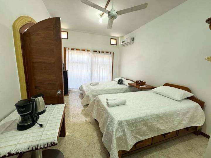 Un dormitorio con dos camas y un ventilador de techo. en Alojamiento Villa Mar, en Puerto Ayora