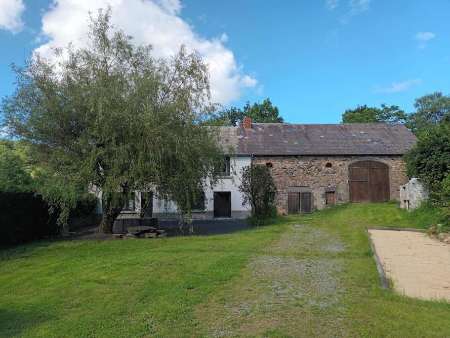 an old stone house with a tree and a field at Gîte La Part des Anges in Saint-Angel