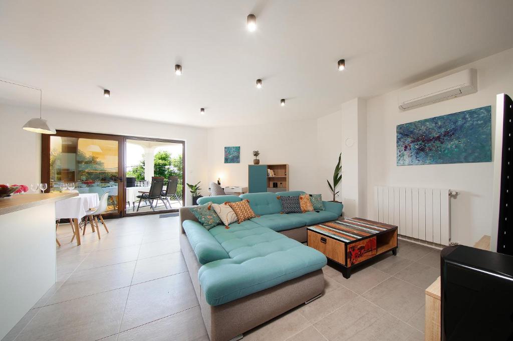 a living room with a blue couch and a table at Apartman Kalinda in Rijeka