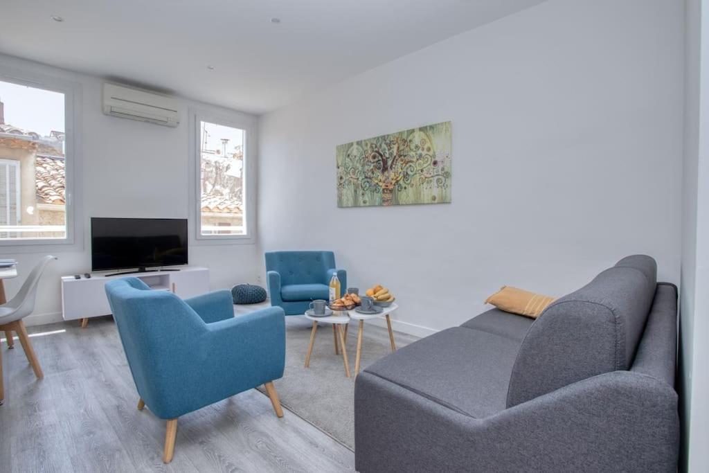 un salon avec un canapé et deux chaises et une télévision dans l'établissement Cahino, déco contemporaine, clim, parking, à La Ciotat