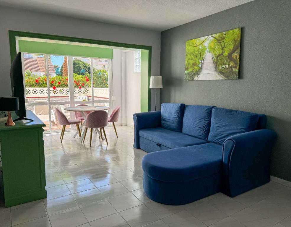 a living room with a blue couch and a table at Casita Helena in Torrox