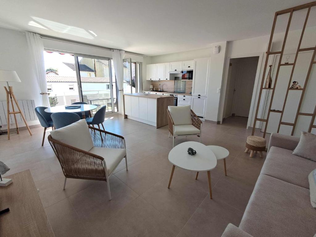 un salon avec un canapé, des chaises et une table dans l'établissement L'Océanide, F2 plage du Bureau, vue mer latérale, à Saint-Palais-sur-Mer